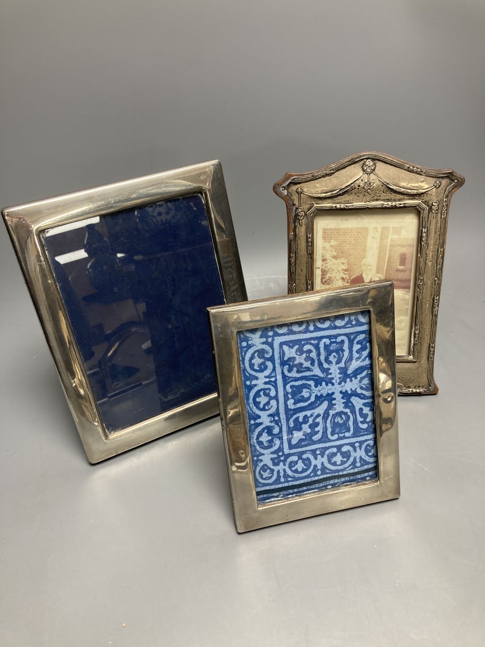 An Edwardian silver mounted photograph frame, Birmingham, 1906, 22.2cm(a.f.) and two others.